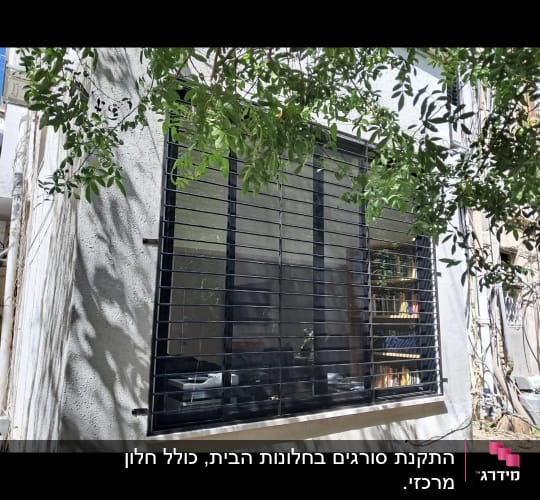 חלון עם סורגים שחורים על קיר חיצוני